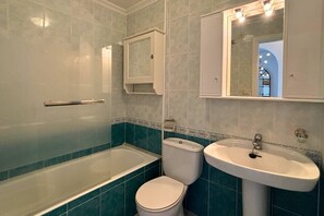 Ein Badezimmer mit einer Badewanne, Toilette und Waschbecken.