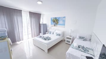Een hotelkamer met een bed, bureau, stoel, televisie en een raam met gordijnen.