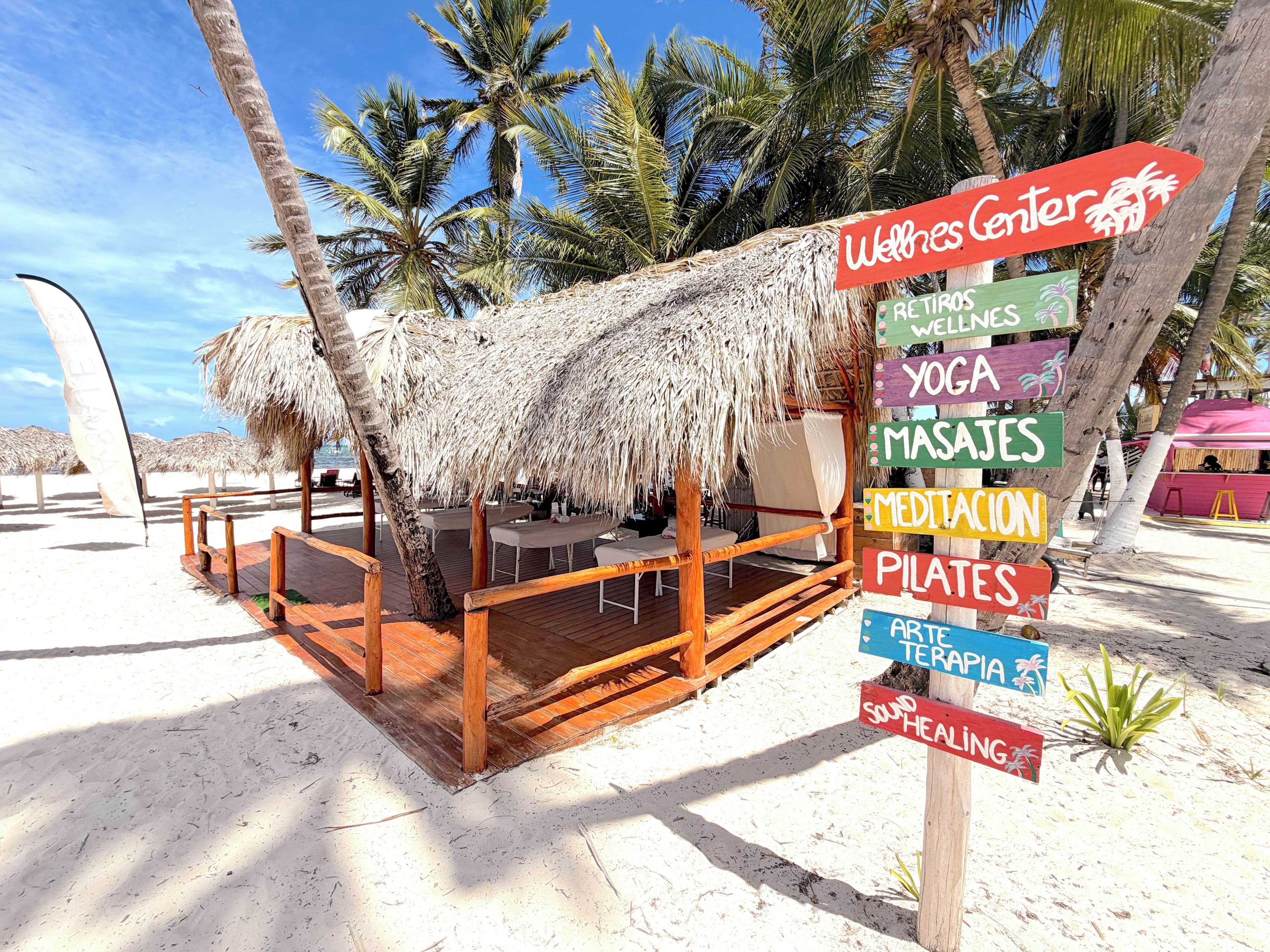 A beachside structure with a thatched roof, wooden deck, and multiple seating areas.