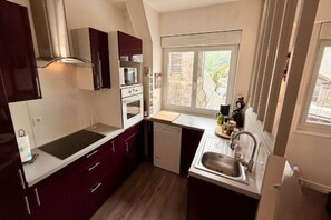 Cozinha compacta com janela, pia e lava-louças.