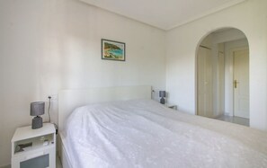 A bedroom with a large bed, bedside lamps, a nightstand, and a framed picture on the wall. - Relaxation on the Costa Calida (Alcazares, Los)