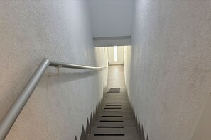 A narrow stairway with a handrail on the left, leading to a landing with a door at the top. - Casa Playa Espejo by Rental Hero (Alcazares, Los)