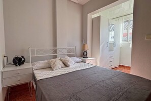 Une chambre à coucher avec un lit, des tables de chevet, une lampe et une armoire.