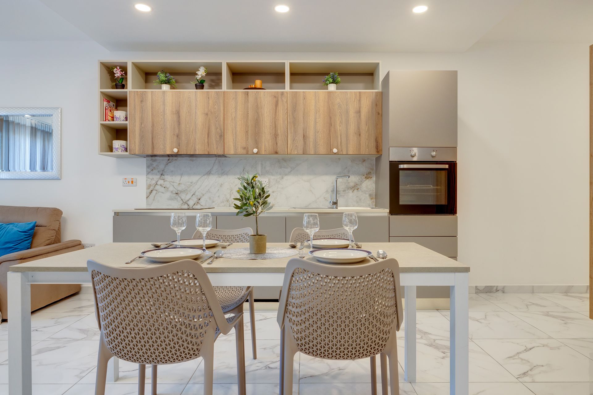 Una cocina moderna con armarios de madera, encimera de mármol y horno.