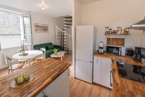 A modern kitchen with a refrigerator, microwave, and coffee maker. - Le Cocon du Bel Air - 500m de la Plage (Saint-Malo)