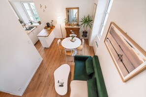 A compact living space with a kitchenette, dining area, and seating area. - Le Cocon du Bel Air - 500m de la Plage (Saint-Malo)