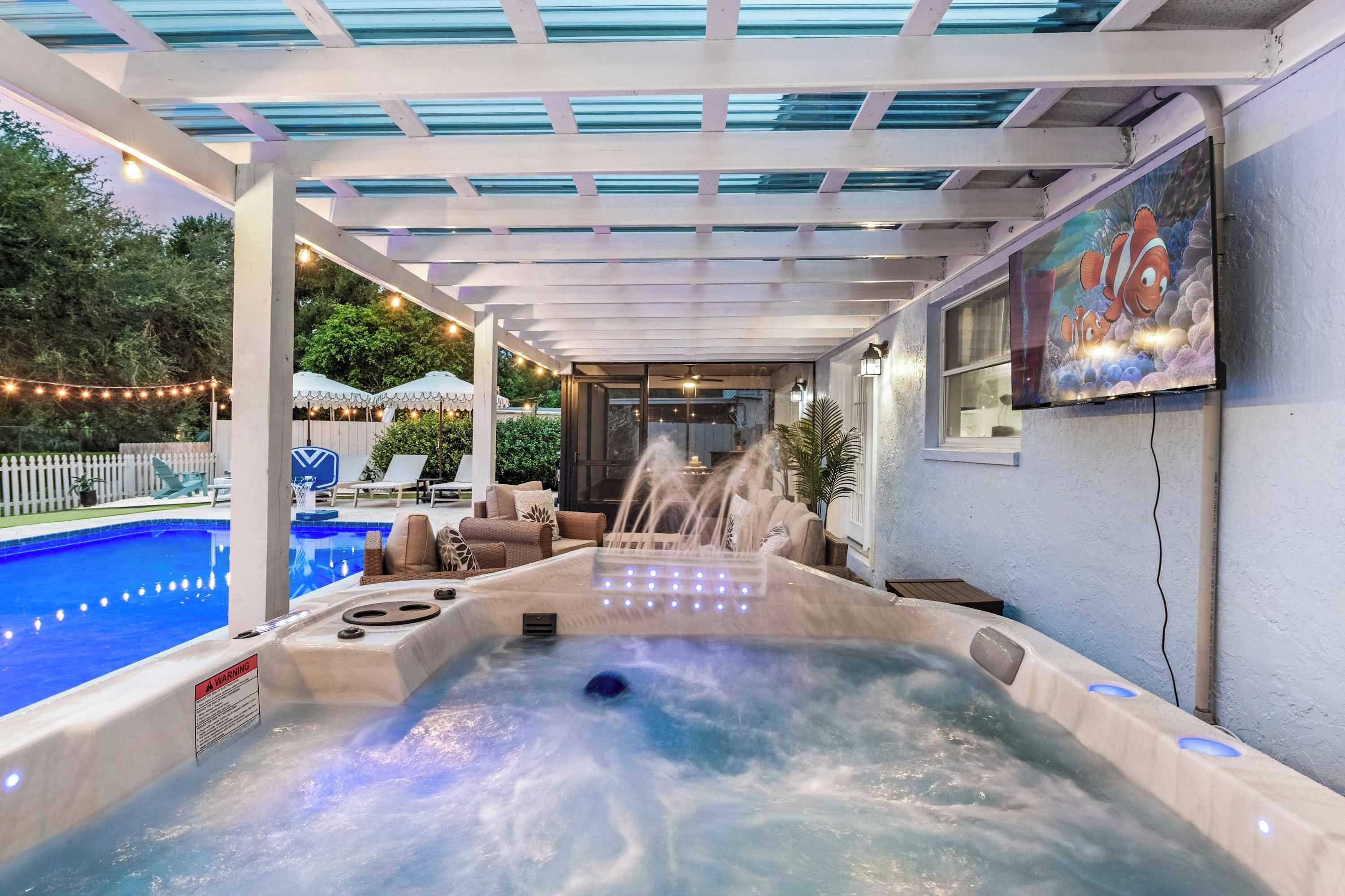 Un área de hidromasaje con piscina, mobiliario exterior y un mural.