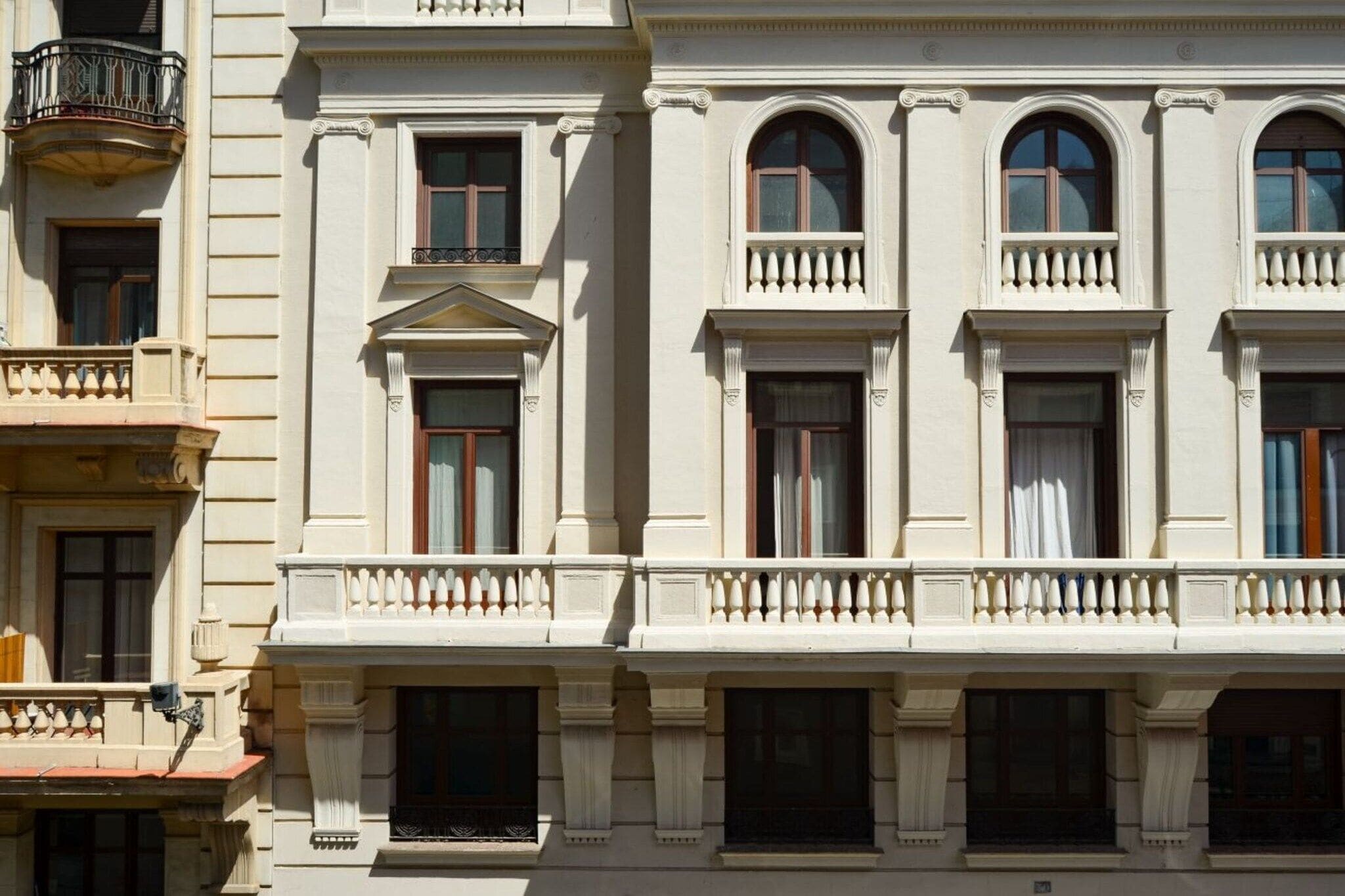 Un edificio de estilo arquitectónico clásico, con ventanas arqueadas y un balcón con balaustradas.
