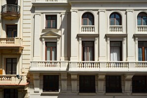 A building with a classical architectural style, featuring arched windows and a balcony with balustrades. - Renovated apartment near Gran Vía (Madrid)