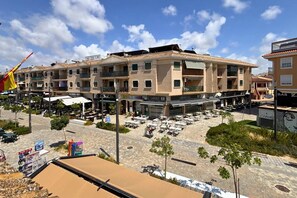 A multi-story building with outdoor seating and a flag. - Casa Rio Nalon by Rental Hero (Alcazares, Los)