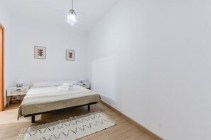 A bedroom with a bed, bedside tables, a hanging light fixture, and two framed pictures on the wall. - Apartment near Plaza de Espana, Madrid (Madrid)