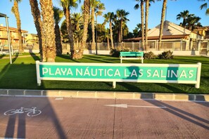 Een bord voor Playa Náutica Las Salinas met een fietspad symbool.