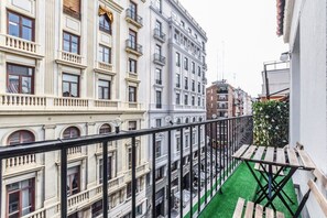 A balcony with a green artificial turf and a wooden table. - Penthouse with Terrace, Plaza Espana (Madrid)