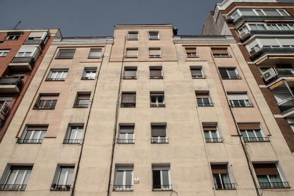 Un immeuble à plusieurs étages, doté d’une façade uniforme, de nombreuses fenêtres et de balcons.