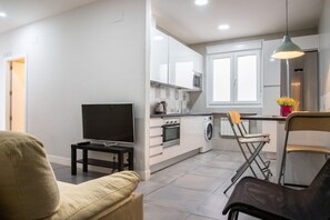 Una cocina moderna con armarios blancos, horno empotrado y microondas.