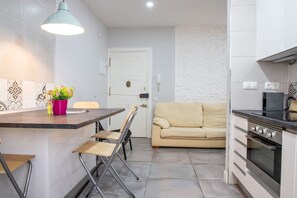 A compact kitchen with a dining area, a sofa, and a kitchenette. - Lush Home in Retiro, Madrid (Madrid)