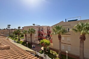 A residential area with multiple buildings, palm trees, and a clear sky. - Casa San Juda by Rental Hero (Alcazares, Los)