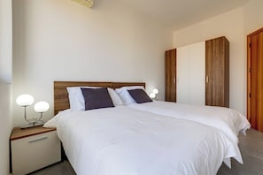 Ein Doppelbett mit Holz Kopfteil, zwei Nachttische mit Lampen und ein Schrank mit Holzausschnitten.