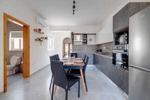 Eine moderne Küche mit Essbereich, ausgestattet mit Backofen, Mikrowelle und Spüle.