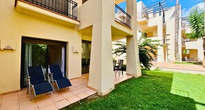 A courtyard with a pool, outdoor seating, and a building with balconies. - Casa Roda Golf by Rental Hero (Roda)