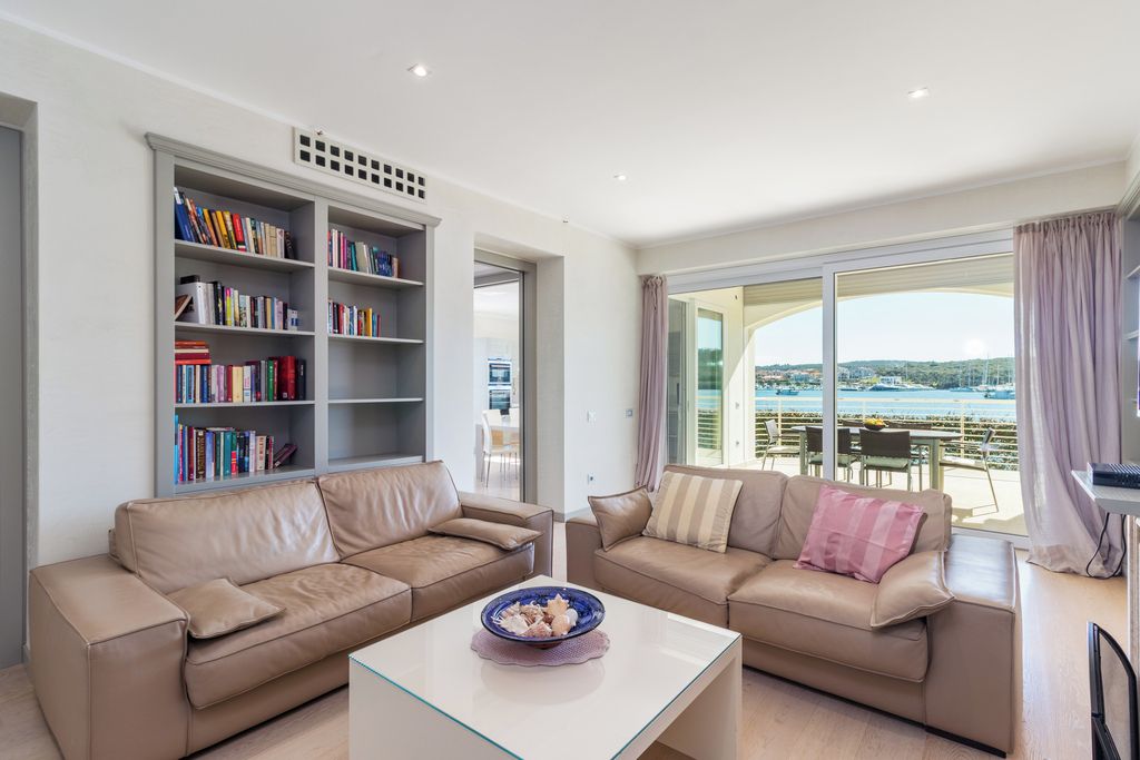Uma sala de estar moderna com dois sofás, uma mesa de centro e uma estante de livros.