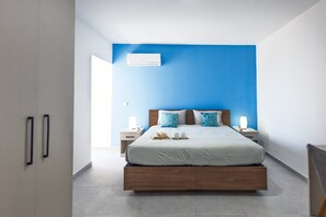 A modern bedroom with a bed, bedside tables, an air conditioning unit, and a view of the outside. - Spacious Penthouse in the Heart of Gharghur (Hal Gharghur)