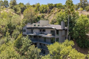 A modern two-story house with a flat roof, surrounded by dense greenery and trees. - Longridge Crest - Gated Studio City Canyon Home (Studio City)