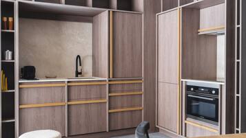 A modern kitchen with built-in appliances, wooden cabinetry, and a small dining area.