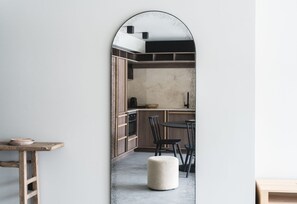 A modern kitchen with wooden cabinets, a black countertop, and a round dining table with chairs. - Les Chalets du Grand Hôtel  (Saint-Chaffrey)