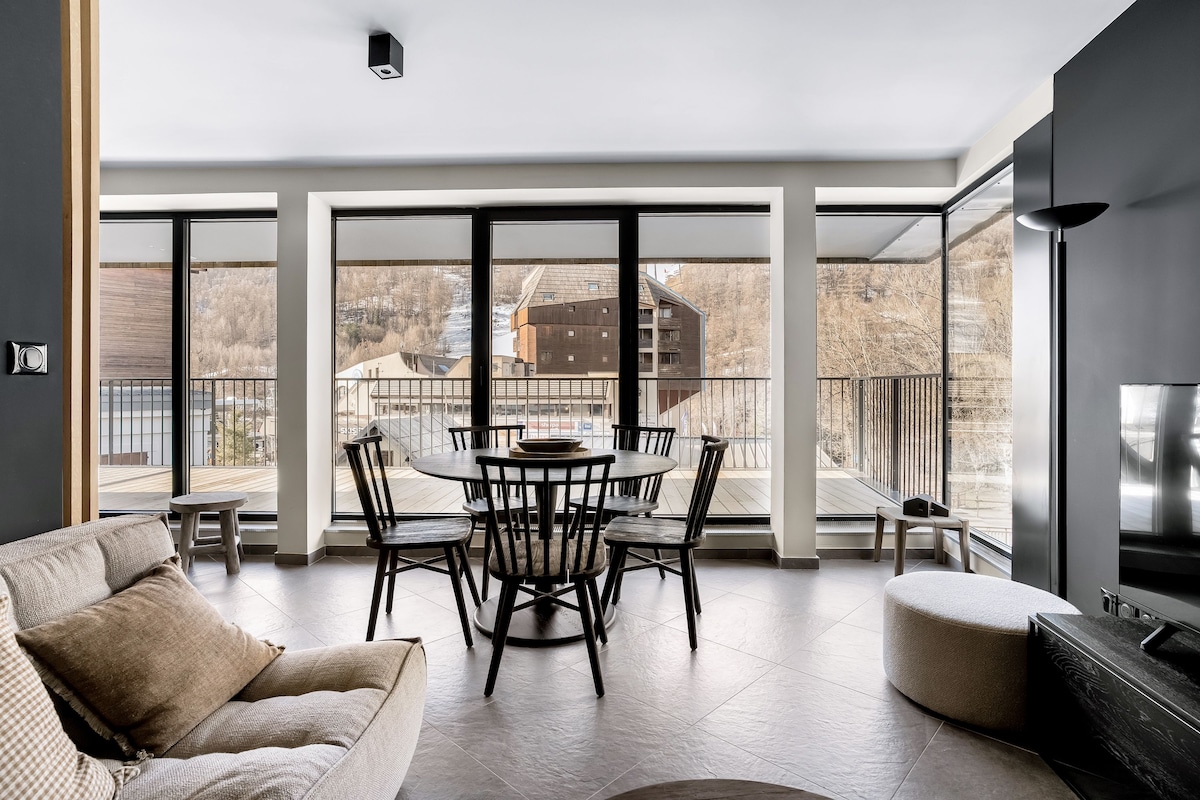 A modern interior with a dining area, a sofa, and a TV.