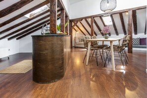 A dining area with a round table, chairs, and a hanging light fixture. - Stay in Historic Madrid Centre (Madrid)