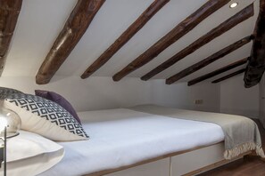 A bedroom with a wooden ceiling, a bed with white bedding, and a lamp on the left. - Stay in Historic Madrid Centre (Madrid)