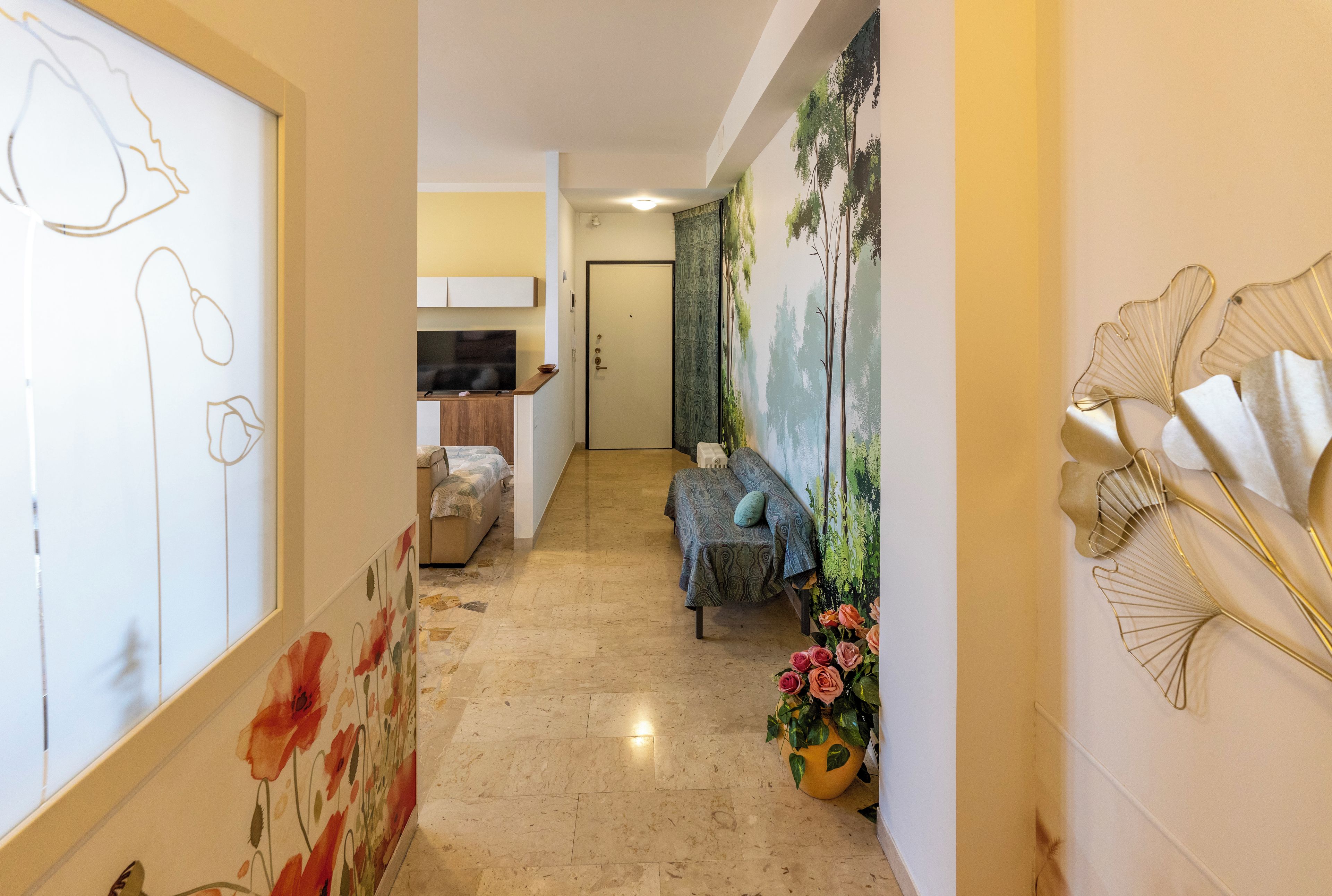 A hallway with a television, a sofa, and a door.