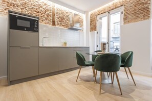 A modern kitchen with a built-in oven, a sink, and a dining area with two chairs. - Apartment with Balcony, La Latina (Madrid)