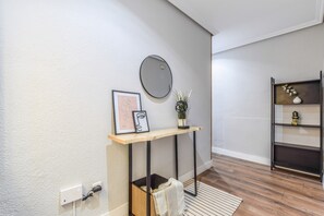 A modern interior with a wooden console table, a round mirror, and a decorative shelf. - Family Apartment, Heart of Madrid (Madrid)