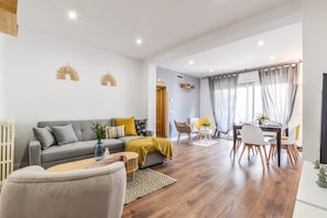 Ein modernes Wohnzimmer mit Sofa, Couchtisch und Essbereich.