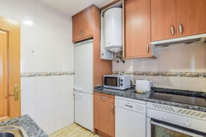 Eine kleine Küche mit Kühlschrank, Mikrowelle, Toaster und Geschirrspüler.