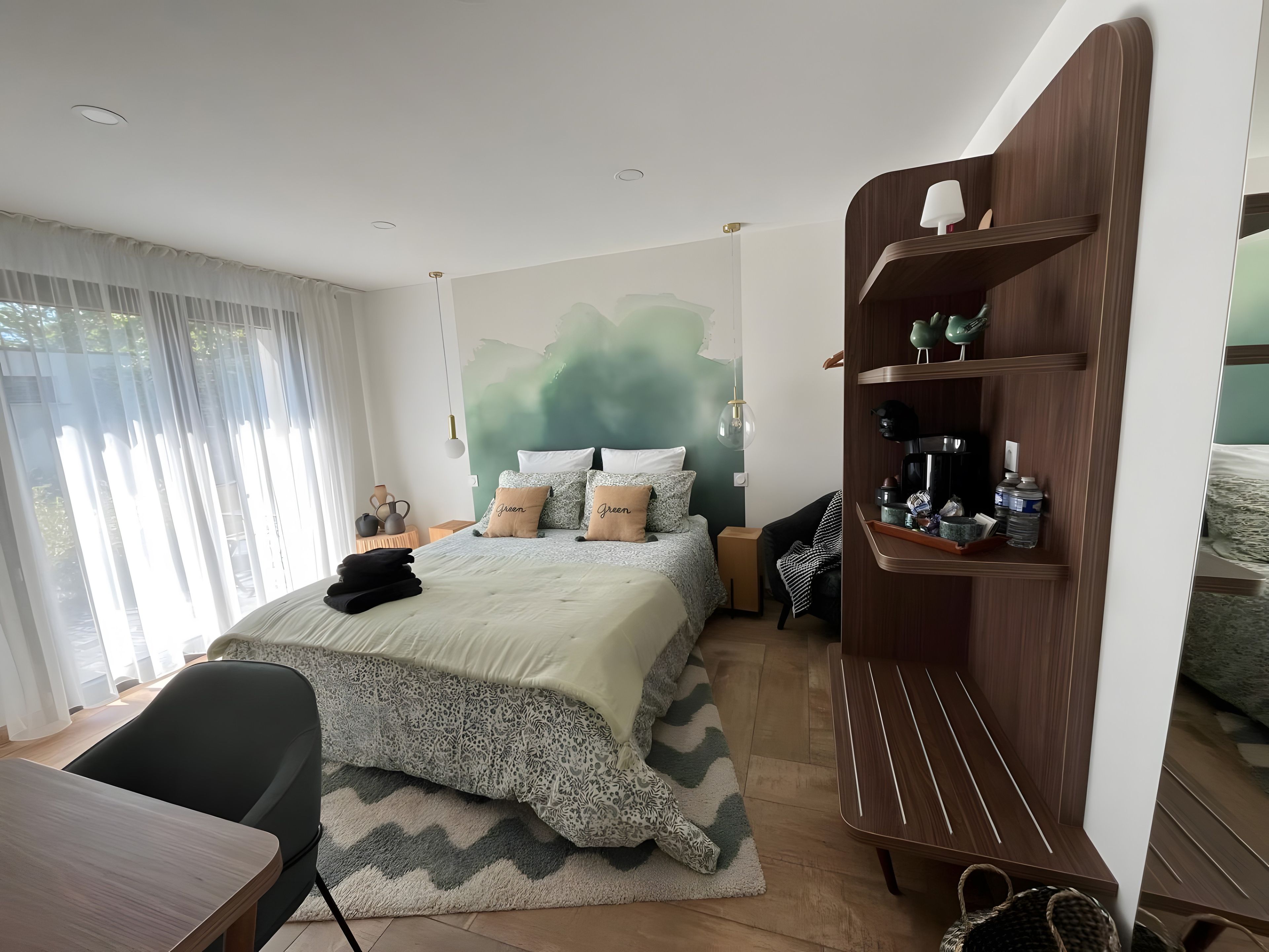 Une chambre à coucher moderne comprenant un lit, des tables de chevet, un bureau et une bibliothèque intégrée.