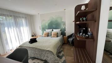 Une chambre à coucher moderne comprenant un lit, des tables de chevet, un bureau et une bibliothèque intégrée.