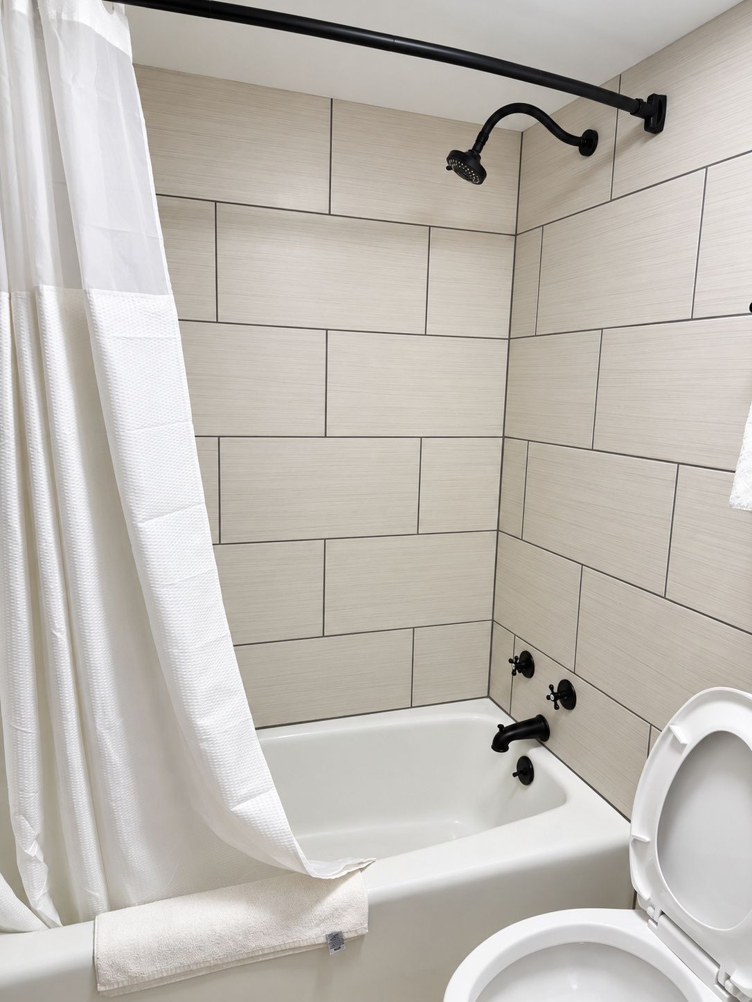 Un baño con bañera, inodoro y cortina de ducha.