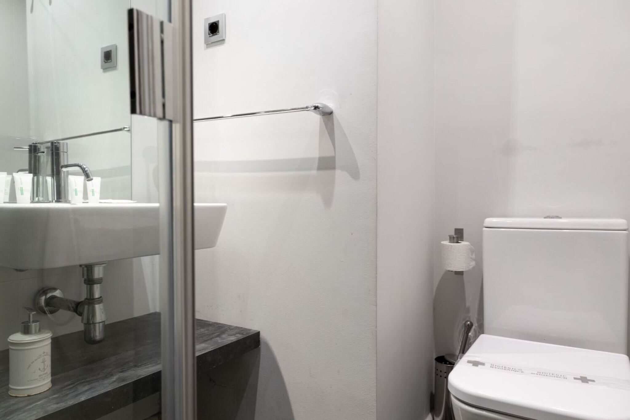 Une salle de bain comprenant des toilettes, un lavabo et un espace douche.