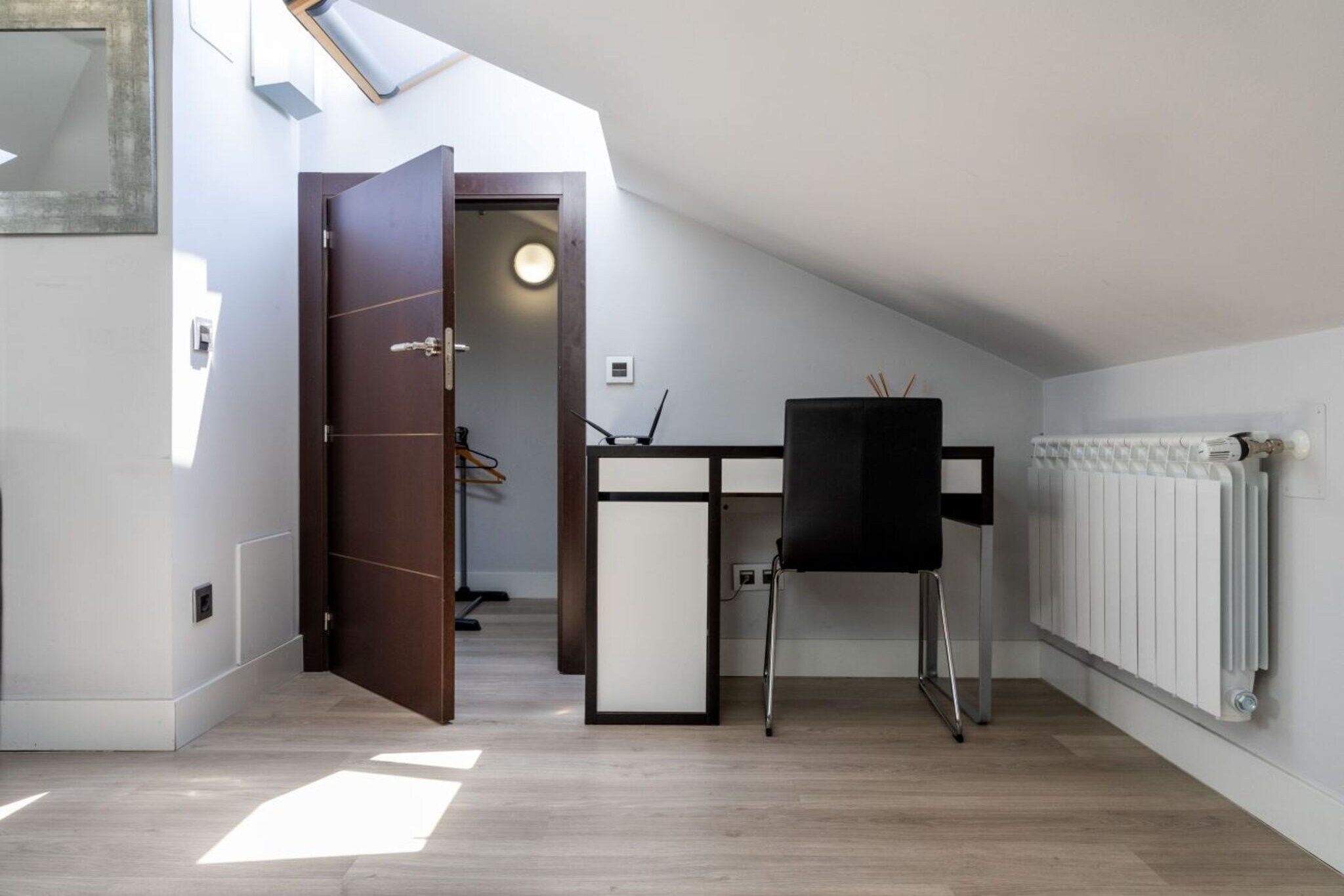 Une chambre moderne équipée d’un bureau, d’une chaise et d’un radiateur.