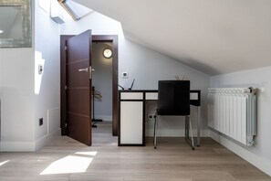 Een moderne kamer met een bureau, stoel en een radiator.