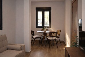 A small dining area with a round table, four chairs, and a potted plant. - Modern Apartment near Las Ventas (Madrid)