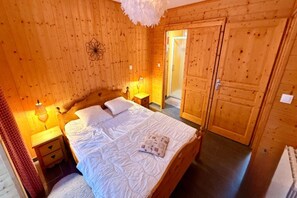 A wooden room with a bed, bedside tables, and a wardrobe. - Family Chalet with Fireplace, Mont-Dore (Mont-Dore)