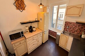 A compact kitchen with a microwave, coffee maker, and a refrigerator. - Mont-Dore Apartment for 8 Guests (Mont-Dore)
