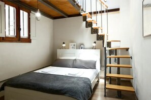 A bedroom with a bed, a wooden ladder, and a window with blinds. - Otomo Flat-Steps from SMN Station&Airport tram (Florence)