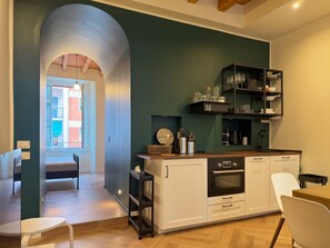 Een moderne keuken met een inbouwoven, een spoelbak en een eethoek met een stoel.
