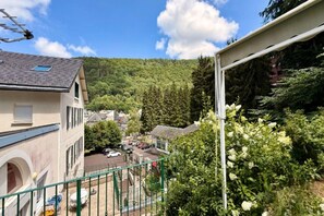 A residential area with houses, a street, and a forested hill in the background. - Apartment with Mezzanine, Mont-Dore (Mont-Dore)