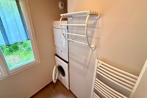 A compact laundry room with a washing machine, dryer, and a drying rack. - Apartment with Mezzanine, Mont-Dore (Mont-Dore)